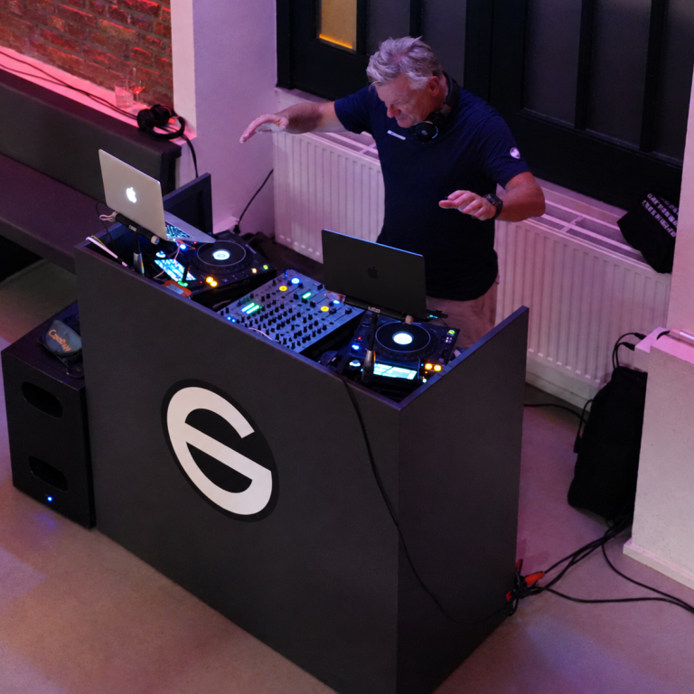 Cassollage live – DJ-Auftritt im Glasvoll Carsten Esser von Cassollage mit erhobenen Händen hinter seinem DJ-Pult im Glasvoll.